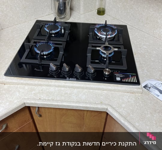 כיריים גז עם ארבעה מבערים דולקים במטבח